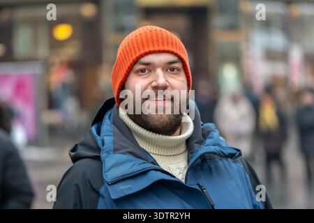 Ritratto di un uomo per strada tra pedoni in inverno. Foto Stock