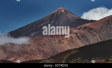 Tenerife, Isole Canarie: Vista aerea del maestoso Monte Teide, la vetta più alta della Spagna, che si innalza sopra le nuvole nello splendido paesaggio di Tenerife. Destinazione del viaggio, contesto naturale. Panorama dei droni Foto Stock