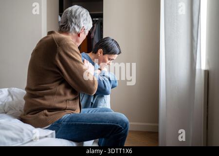 Relazioni tossiche e manipolazioni, marito narcisistico che calma la moglie stanca mentalmente. Foto Stock