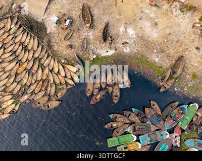 Vista aerea delle vivaci barche attraccate lungo la riva del fiume, con i loro scafi colorati che contrastano con l'acqua torbida, Dhaka, Dhaka Division, Banglade Foto Stock