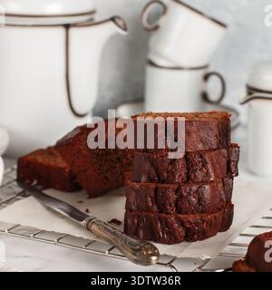 Pane per torte fatto in casa con chili di cioccolato a fette. Delizioso dessert. Una delizia per tè o caffè. Colazione su un tavolo di marmo contro un muro di cemento grigio. SEL Foto Stock