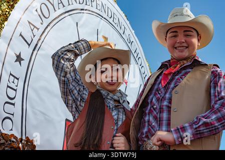 Giovane donna e uomo che indossa cappello da cowboy, camicie e gilet a quadri su un galleggiante nella Parade of Oranges, City of Mission, Texas, USA. SOLO PER USO EDITORIALE Foto Stock