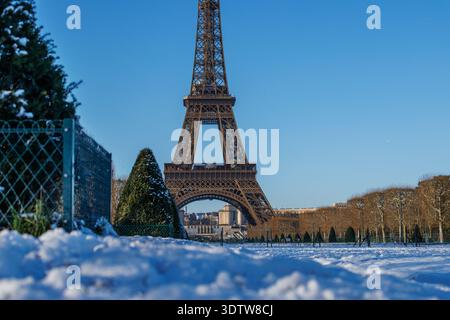 La Torre Eiffel si erge maestosamente in inverno, incorniciata da un terreno innevato rare condizioni meteorologiche in questa pittoresca scena parigina Foto Stock