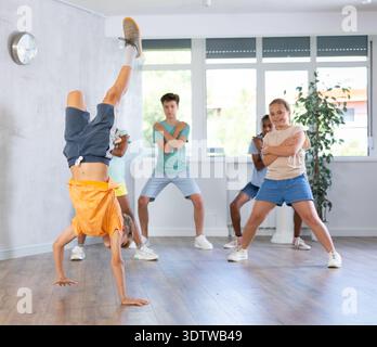 Preadolescente che fa salti di mano durante l'allenamento in classe di danza Foto Stock