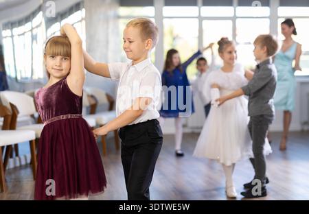 Danze classiche eseguite da bambini preadolescenti in abiti festivi Foto Stock