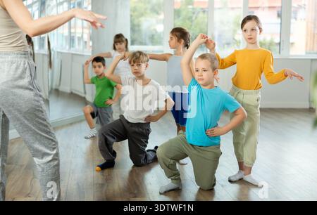 Le ragazze preadolescenti e i ragazzi imparano a ballare balli classici nello studio coreografico Foto Stock
