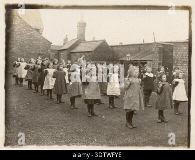 Foto d'epoca anni '1900 i bambini delle scuole edoardiane, che si allenano all'aperto, nel cortile scolastico degli anni '1900, le ragazze indossano pinafores classe scolastica vittoriana circa 1905 Regno Unito Foto Stock