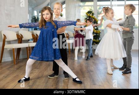 Spettacolo di Capodanno - i bambini vestiti splendidamente ballano balli classici al ballo di Natale Foto Stock