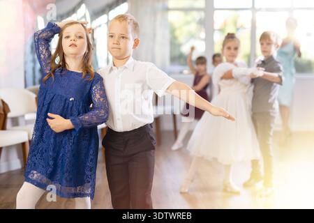 Entusiasti bambini preadolescenti che ballano valzer a coppie nella scuola di danza Foto Stock
