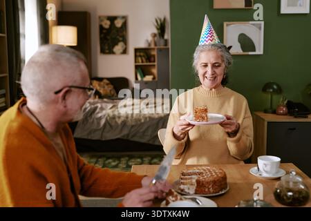 Donna caucasica anziana sorridente mentre festeggia il compleanno con l'uomo anziano Foto Stock