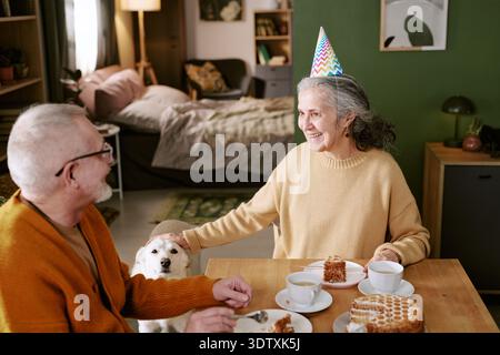 Donna caucasica anziana sorridente e festeggia il compleanno con uomo anziano al chiuso Foto Stock