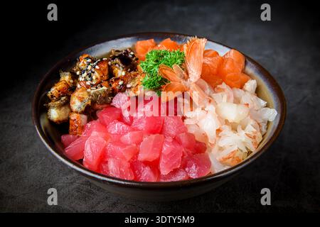 Colorato sushi chirashi con tagli assortiti di sashimi, anguille grigliate e gamberi freschi, serviti su sfondo scuro, che mettono in risalto il Giappone tradizionale Foto Stock