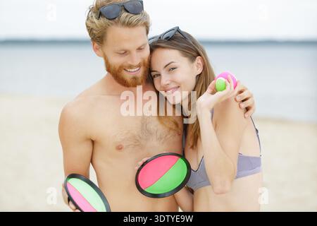 amici che giocano con i frisbee sulla spiaggia Foto Stock
