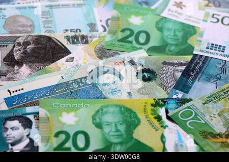 Varie valute banconote banconote di colore verde. Molte banconote in contanti da diversi paesi in grande pila da vicino. Economia mondiale e concetto di cambio valuta Foto Stock