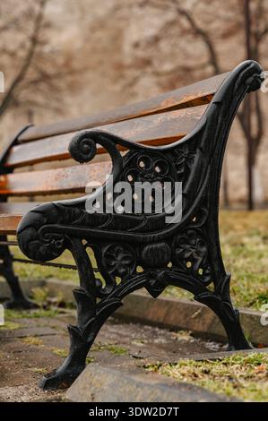 Sedili riflettenti silenziosi. Ambiente tranquillo con intricati dettagli in ferro e legno invecchiato Foto Stock