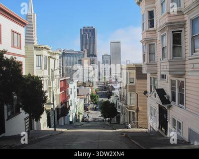Una prospettiva a livello della strada che conduce lo sguardo verso lo skyline distante. La scena fonde la vita urbana quotidiana con l'architettura riconoscibile della città. Foto Stock