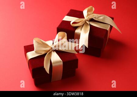 Bellissime confezioni regalo in velluto su sfondo rosso, primo piano Foto Stock