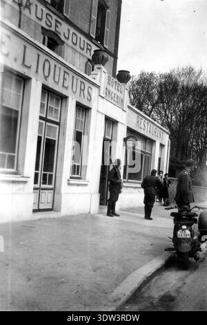Due soldati tedeschi che parlano con due donne francesi fuori da un ristorante a Donville les Bains. Foto Stock