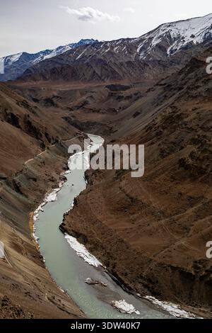 Un fiume tortuoso scorre attraverso le aspre montagne di Ladakh, India, mostrando una bellezza naturale mozzafiato. Foto Stock