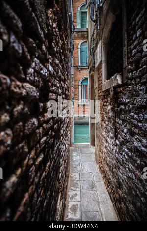 Uno stretto vicolo di Venezia offre uno scorcio dell'architettura storica della città. Foto Stock