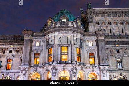 Vista notturna dell'architettura storica illuminata e della facciata ornata del teatro dell'opera Palais Garnier a Parigi, Francia. Foto Stock