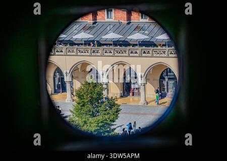 Archi di Cloth Hall visti attraverso una finestra circolare, la piazza principale del mercato, Cracovia, Polonia Foto Stock