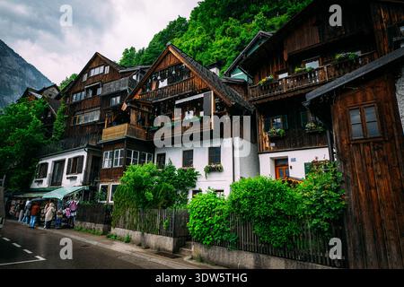 Affascinanti case in legno accoccolate su una ripida montagna verde in un villaggio europeo Foto Stock