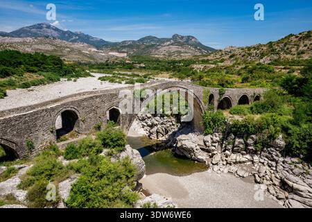 Vista panoramica del Ponte mesi, un monumentale ponte ad arco in pietra del XVIII secolo costruito intorno al 1770 dal pascià ottomano locale, Kara Mahmud Bushati. Loca Foto Stock