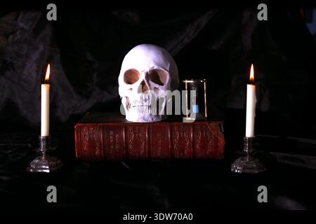 Teschio umano e candele ancora in vita. Foto Stock