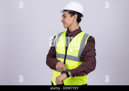 Ritratto completo del lavoratore in giubbotto di sicurezza e casco Foto Stock