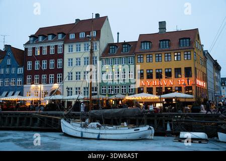 Colorati edifici storici e barche al porto di Nyhavn durante la sera d'inverno a Copenhagen Foto Stock