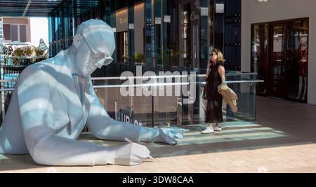 Una donna parla con uno smartphone in un centro commerciale nel Design District, Miami, Florida, Stati Uniti Foto Stock
