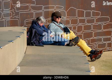 Coppia di anziani che si addormentano al sole mentre si siede sui gradini sul lungomare di Southsea a Portsmouth, Hampshire, Regno Unito Foto Stock