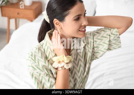Bella donna con coda di cavallo e scrunchies in camera da letto, primo piano Foto Stock