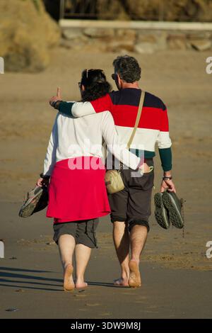 Coppia di mezza età passeggiando sulla spiaggia di Bakio, Paesi Baschi, Spagna Foto Stock