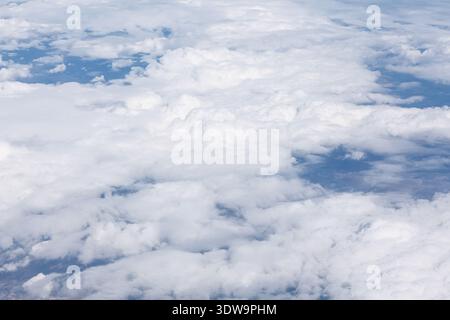 Vista aerea mozzafiato di soffici nuvole bianche si estende attraverso il cielo, creando un paesaggio morbido e da sogno. La luce del sole illumina delicatamente la parte superiore della nuvola Foto Stock