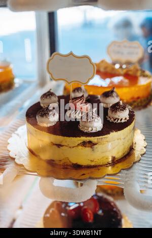 Dessert dolce con dolci a strati e condimenti di panna in un ambiente da forno Foto Stock