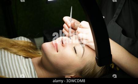 Procedura di estensione eyelash in primo piano salone di bellezza Foto Stock