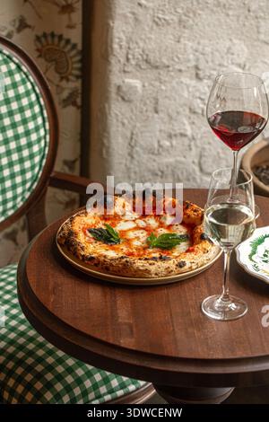 Classica pizza margherita con bicchieri da vino Foto Stock