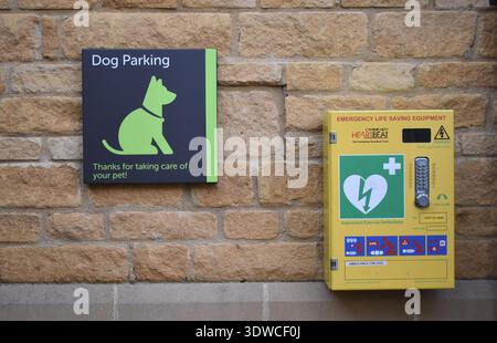Cartello "Dog Parking" e defibrillatore su Broadway High Street. Foto Stock