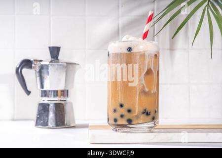 Classico boba bobble tea con perle di tapioca e crema non casearia montata sopra il bicchiere, dolce dolce dolce estivo su sfondo bianco della tavola c Foto Stock