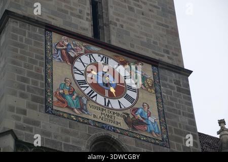 La torre dell'orologio di Brasov in Romania mostra un grande quadrante con opere d'arte e numeri romani in una giornata nuvolosa. Foto Stock
