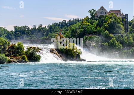 Una vista panoramica delle Cascate del Reno, la più grande cascata d'Europa, con Schloss Laufen sullo sfondo. La potente cascata d'acqua si abbassa, creando una nebbia Foto Stock