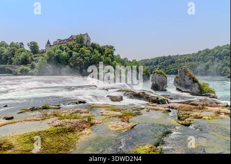 Una splendida vista aerea delle Cascate del Reno in Svizzera, che mostra le potenti acque a cascata e lo storico castello Schloss Laufen arroccato su una Foto Stock