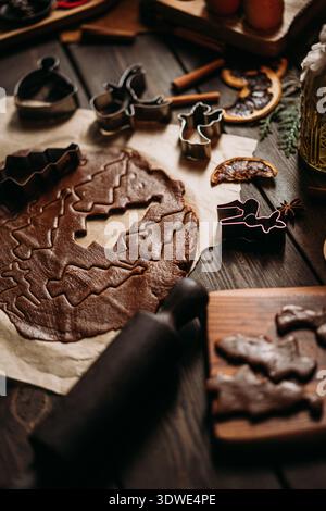 I biscotti al pan di zenzero vengono preparati con varie taglierine per le feste. Il ricco impasto marrone viene arrotolato, circondato da spezie e ingredienti che coprono Foto Stock