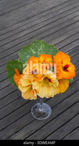 In un bicchiere di vino su un tavolo da giardino in legno Foto Stock