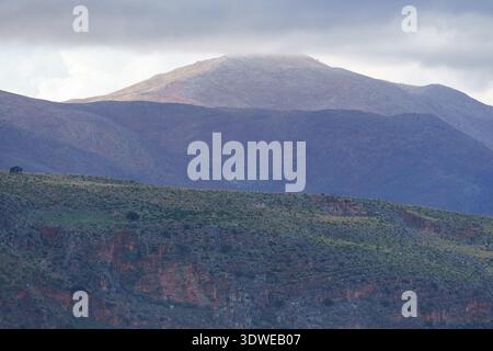 Una foto mozzafiato che cattura la bellezza intensa e ad alto contrasto delle montagne costiere siciliane vicino a Castellammare del Golfo. Nuvole pesanti e scure Foto Stock