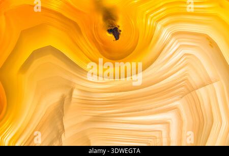 Macrofotografia dei pattern di banda in una fetta di agata brasiliana; pattern e colori sono migliorati dalla retroilluminazione; Agate è un From di criptocristallo Foto Stock