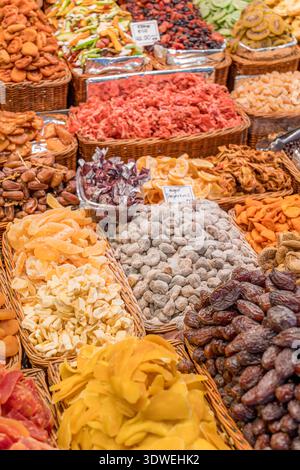 Una vivace esposizione di frutta secca in un ambiente di mercato. I cestelli contengono una serie di texture e colori, offrendo un ricco pattern visivo di Foto Stock