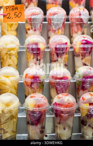 Le colorate coppette di frutta disposte a griglia creano una texture visiva vibrante presso uno stand del mercato. Ogni tazza presenta un delizioso mix di freschi e succosi Foto Stock